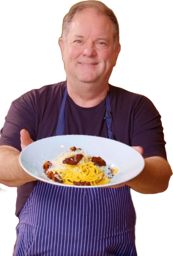 Chef Keith Kuhn holding a plate of spaghetti carbonara